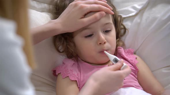 Woman is Measure the Temperature of Little Girl