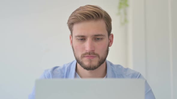 Portrait of Young Creative Man with Laptop Looking at Camera
