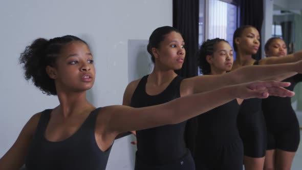 Multi-ethnic group of fit female modern dancers practicing a dance routine