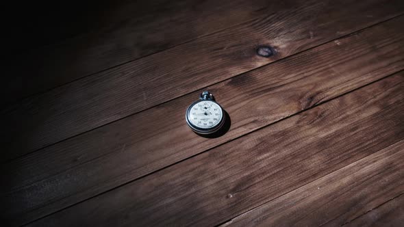 An Antique Stopwatch Lies on Wooden Table and Counts the Seconds Timelapse