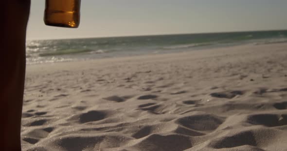 Couple toasting beer bottles on the beach 4k