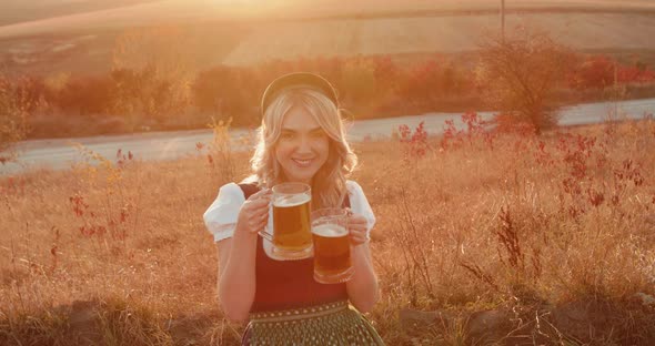 Pretty Slavic Girl in Ethnic Dress Cheers Two Pints of Beer and Smiles on Nature