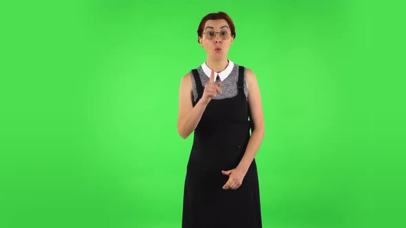 Funny Girl Is Listening Attentively and Nodding His Head Pointing Finger at Viewer, Green Screen
