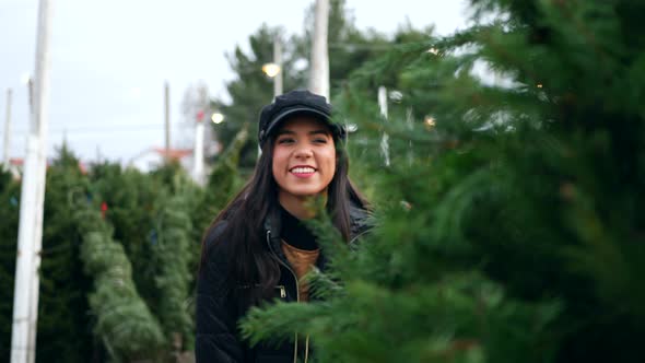 A beautiful woman in a happy holiday spirit smiling while shopping for festive douglas fir Christmas