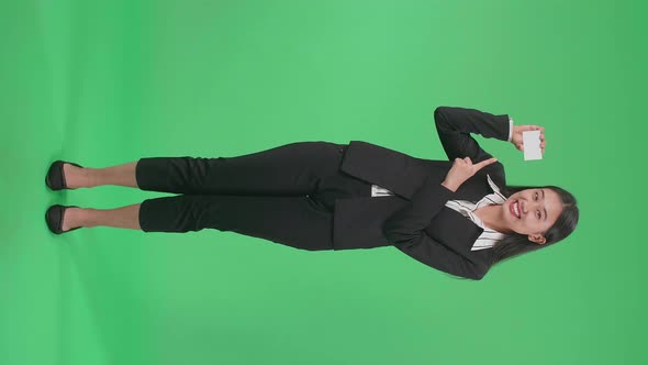 Full Body Of An Asian Business Woman With Smile Pointing A White Card On Green Screen