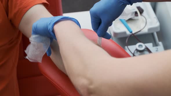 A Nurse Bandages a Patient After Having Venous Blood for Analysis. Blood Donation Concept