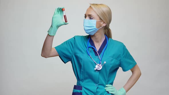 Medical Doctor Nurse Woman Wearing Protective Mask and Latex Gloves - Holding Blood Test Tube