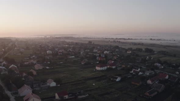 Aerial Drone View Over Old Village at Sunrise. Thick Fog Covered All the Fields