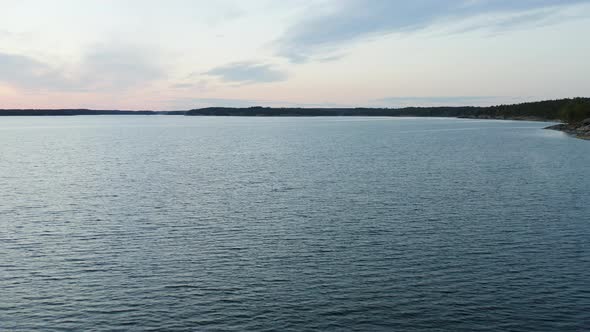 Aerial view over the calm sea of the Gulf of Finland and silhouette coast of Porkkala bay, on a sunn