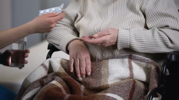 Medical Worker Bringing Pills to Old Female Patient Suffering From Fatal Disease