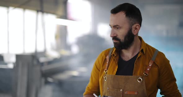 Factory Worker with Tablet and Phone at the Manufacturing