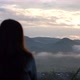Blurred rear view of a female traveler looking at a beautiful mountain views on foggy day - VideoHive Item for Sale
