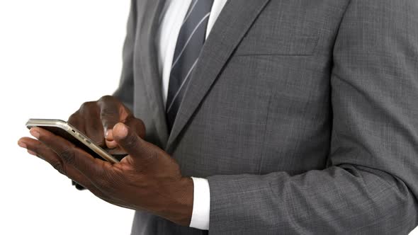 Mid-section of businessman using mobile phone