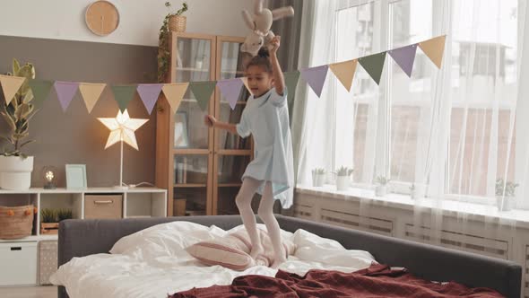 Little Girl Jumping on Bed