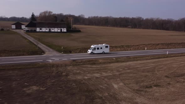 Angled Flyover Shot of a White Camper Van Taken on a Drone