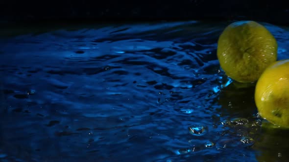 Super Slow Motion Shot of Rolling 2 Limes Splashing Water From Rotating Lime Slice