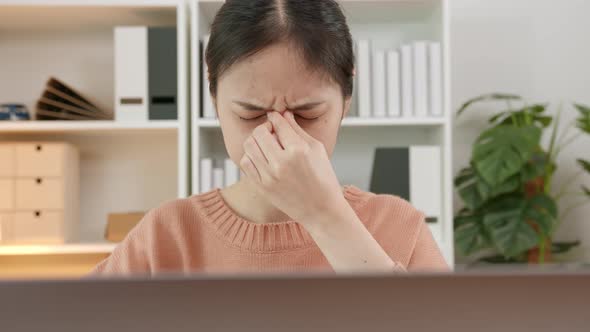 woman using laptop and feeling eye strain at home office after long working on computer