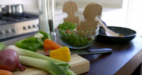 Bowl of salad and fresh vegetables kept on kitchen worktop