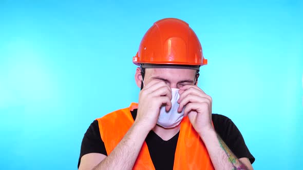 Portrait of Young Man in Medical Mask on His Face on Blue Background