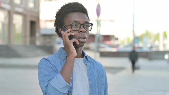 Angry Young African Man Talking on Phone Outdoor