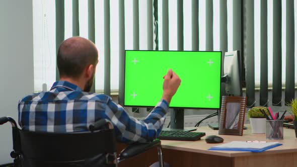 Businessman in Wheelchair Using Computer with Chroma Key