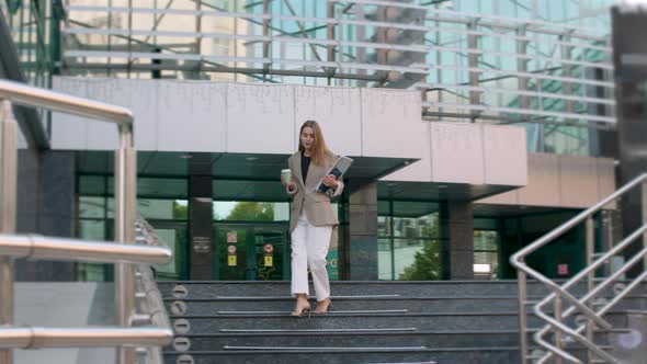 Business Woman Dressed in a Suit and High Heels Very Elegantly Descends the Stairs of a Business