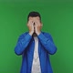 The Man Covers His Face with His Hands While Playing Over Green Background - VideoHive Item for Sale
