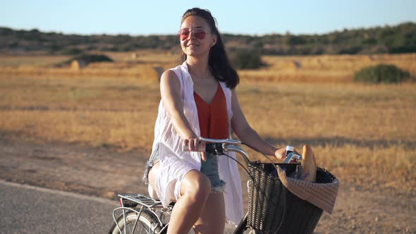 Gorgeous Confident Woman in Sunglasses with Bike Looking Around Admiring Beauty of Cyprus Nature at