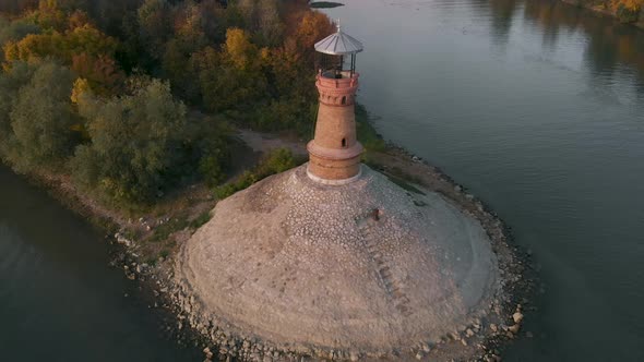 Amazing revealing drone footage of the old stone lighthouse by the Danube river. Beautiful autumn co