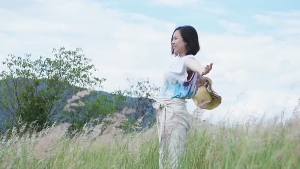 Portrait of Asian beautiful young woman freshness morning breathe deep and throw hat in nature