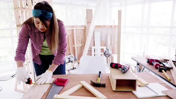 Stylish craftswoman working in carpentry. Woodwork and furniture making concept.