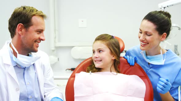 Portrait of smiling dentists and young patient showing thumbs up