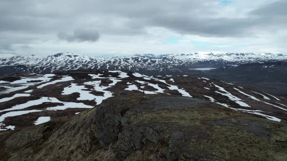 Aerial View Of Person Standing On Hilltop In Hardangervidda National Park Over Snow Covered Landscap