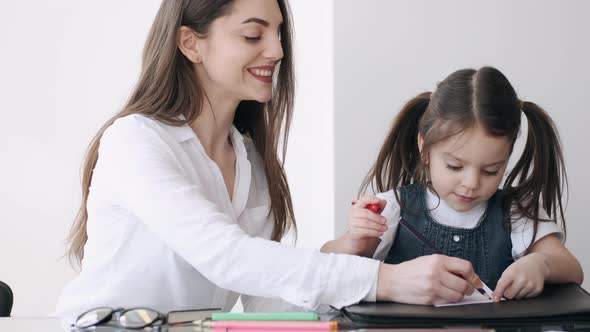 Mother and Daughter Are Coloring a Picture Together