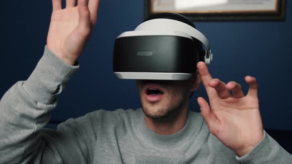 Slow Motion Scene Video of a Caucasian Man Using a VR Device To Play Video Games at Home.