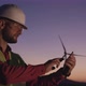 Engineer Browses Information in the Phone Standing on the Background of Windmills at Sunset - VideoHive Item for Sale