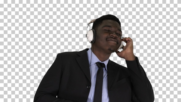 Black businessman dancing to music in headphones, Alpha Channel