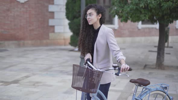 Slow Motion Of A Young Woman Walking At The Plaza With Bicycle