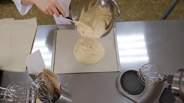 Closeup of a Female Cook Pouring Liquid Cake or Pie Batter Into a Baking Dish