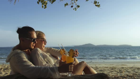 Loving Couple in White Dress Sunglasses in Hugging Relax and Drinking Cocktail