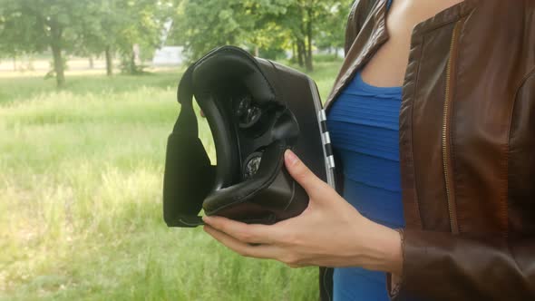 Sexy Young Woman Looking At A Virtual Reality Helmet In The Park