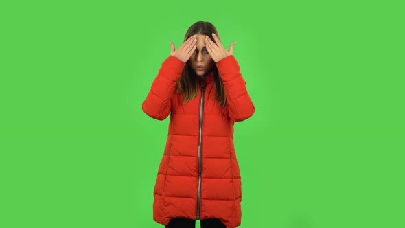 Lovely Girl in a Red Down Jacket Is Cooling Herself By Her Hand, Suffering From High Temperature