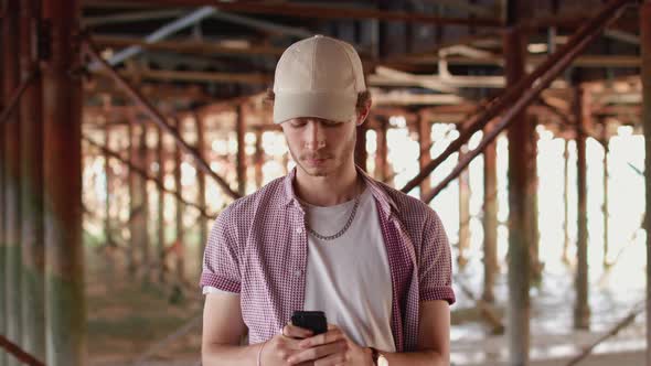 Man Stood Under Pier Making a Purchase His Phone and Then Smiles To Camera