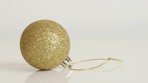 Golden color Christmas ornament on white background  4K 2160p 30fps UltraHD tilting  footage - Shiny