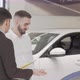 Handsome Businessman Talking to Salesman at Car Dealership - VideoHive Item for Sale