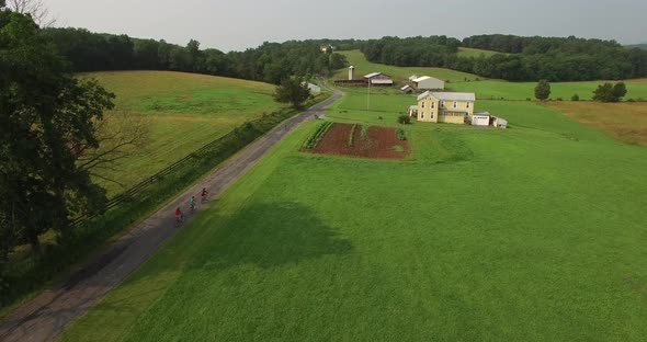 Aerial views of family bicycling along pastoral country roads.