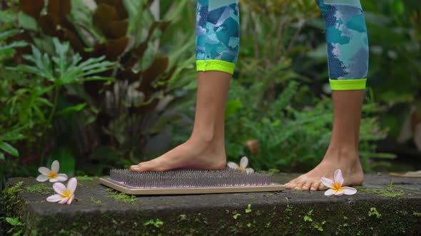 Slowmotion Shot of a Young Woman That Using a Sadhu Board or a Nail Board in a Tropical Surrounding