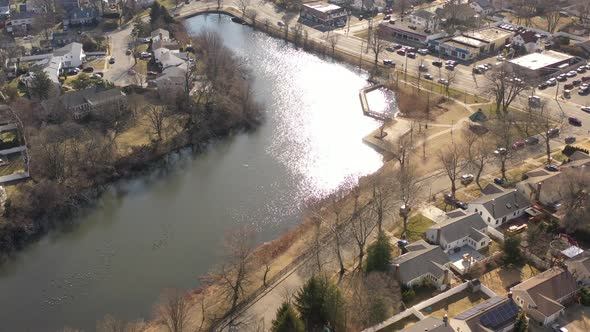 A bright and sunny morning flying over a green pond, shot with a drone. The camera truck right and p