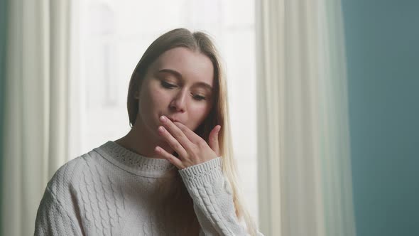 Blonde Girl in White Jacket Holding Chopsticks for Sushi and Licks Fingers