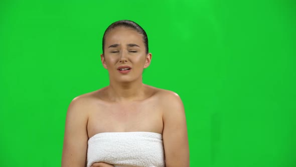 Cute Female with Bare Shoulders in White Towel Feels Very Bad, Her Stomach Hurts, Green Screen